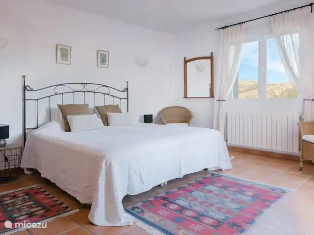 Location de Vacances Espagne, Costa Blanca, Dénia, villa - Casa Aldefa Une chambre lit king size avec une vue imprenable et dispose d'une grande salle de bain attenante.