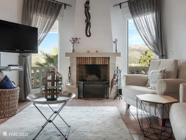 Location de Vacances Espagne, Costa Blanca, Dénia, villa - Casa Aldefa Un salon confortable avec un mobilier confortable, une cheminée et une télévision avec chaînes néerlandaises.