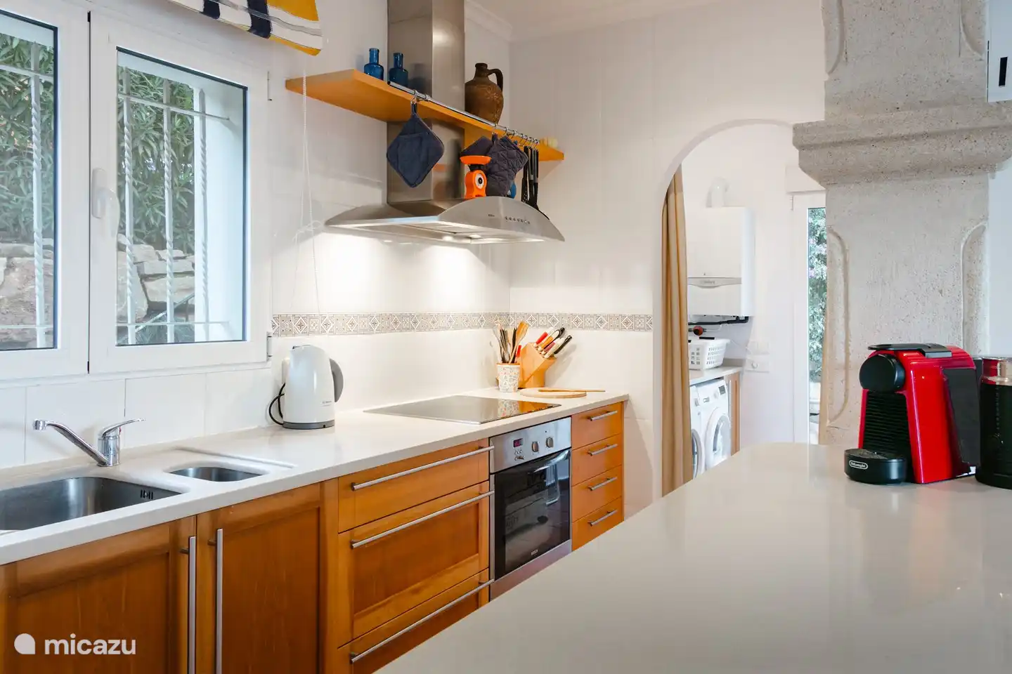 Die gut ausgestattete offene Küche mit Geschirrspüler, Herd, Backofen und Nespresso-Kaffeemaschine.