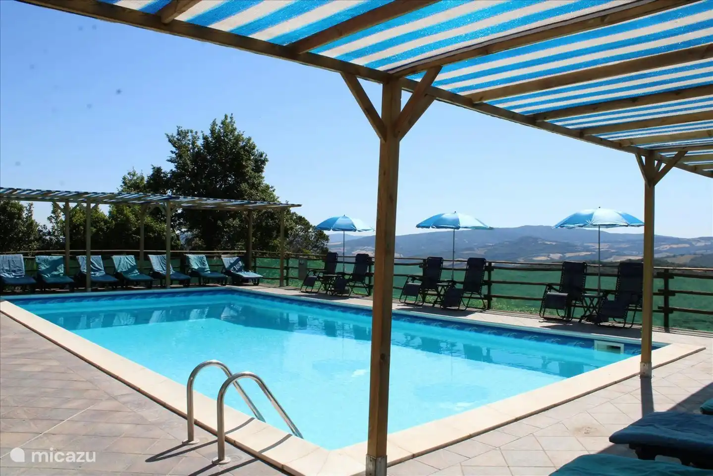 Piscine avec transats et fauteuils relax