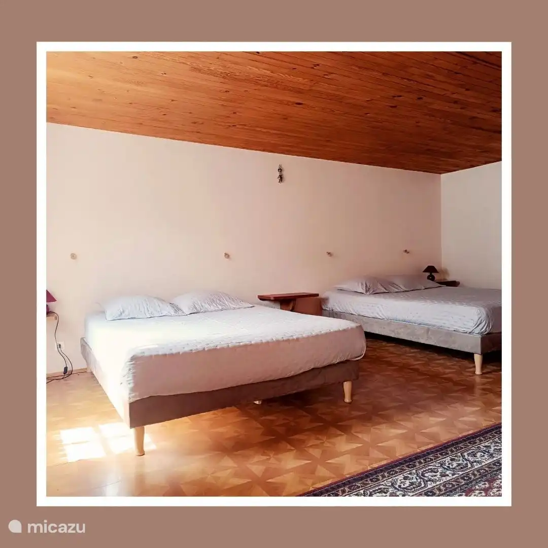 Das geräumige Schlafzimmer verfügt über zwei Doppelbetten. 