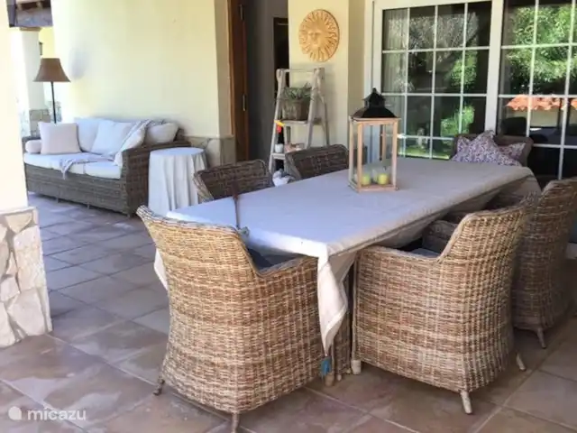 Belle villa double | Espagne, Costa Brava, Calonge - villa En entrant dans le jardin on arrive immédiatement à la terrasse couverte avec les portes coulissantes du salon de l'appartement à droite et la porte d'entrée à gauche.