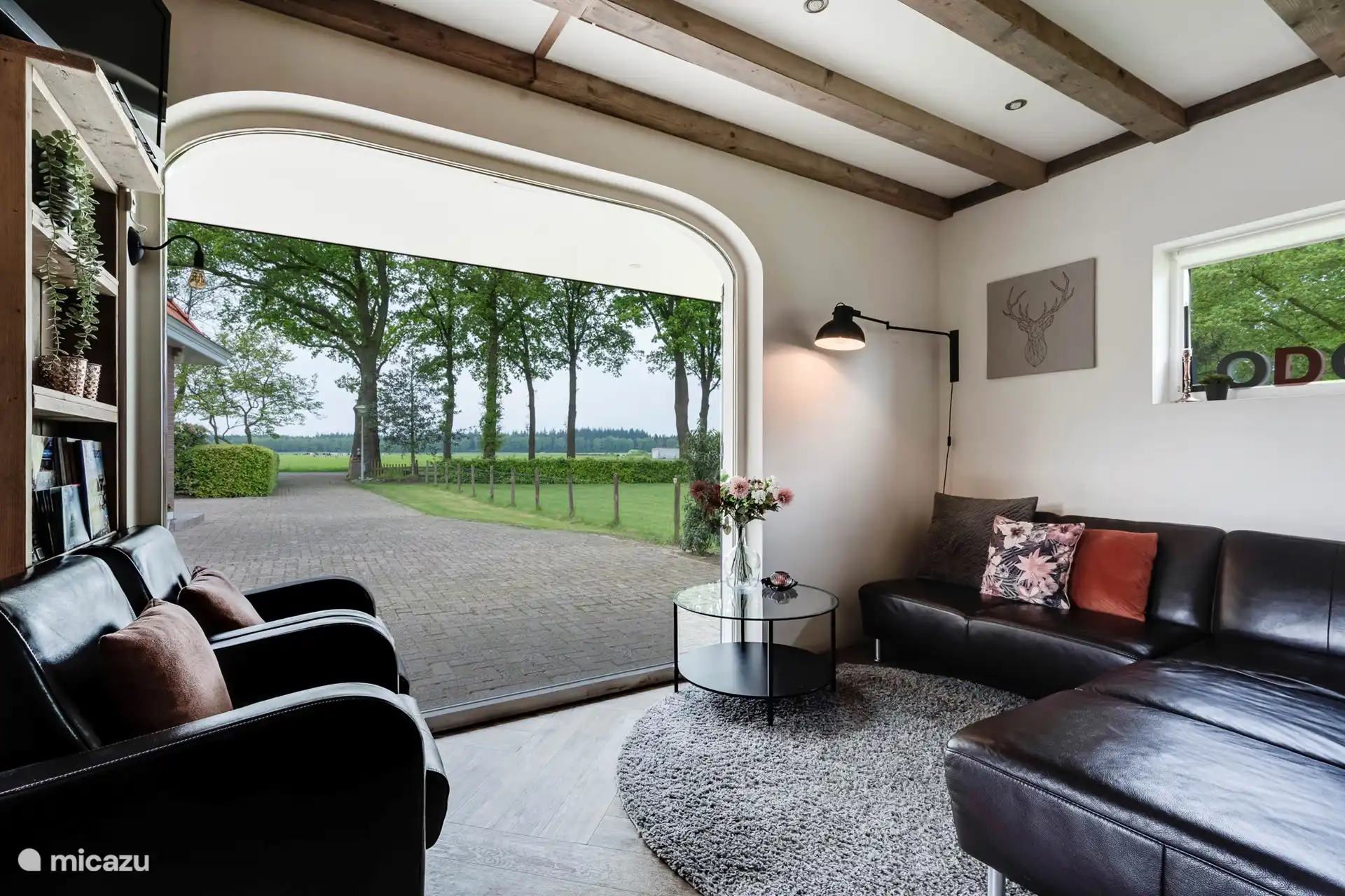 Das Wohnzimmer mit Panoramafenster mit Blick auf die Wiesen und Wälder