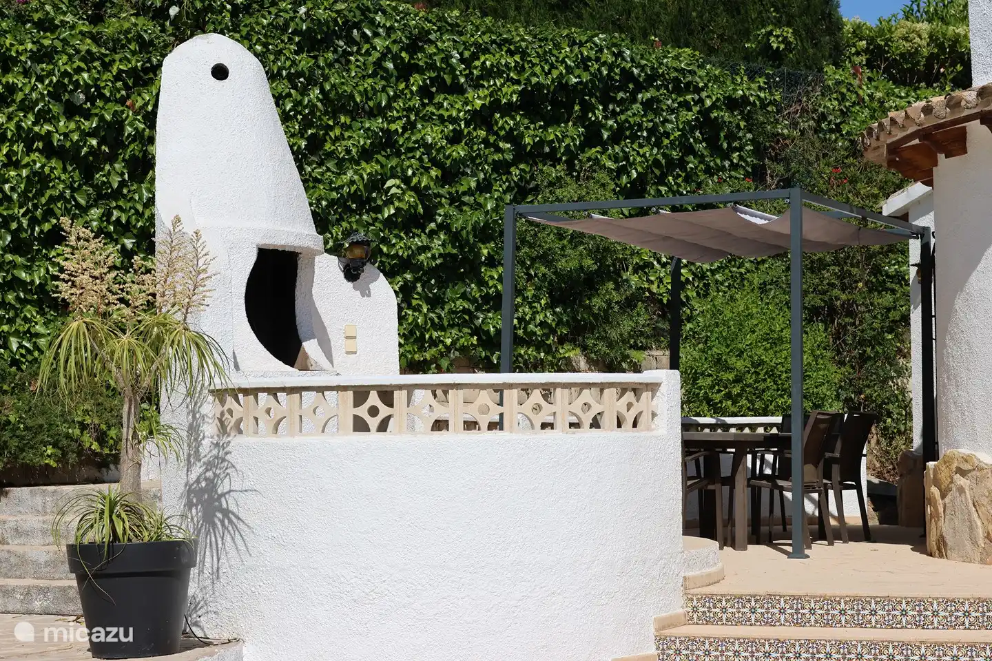 Acogedor rincón de barbacoa con mesa de comedor al aire libre