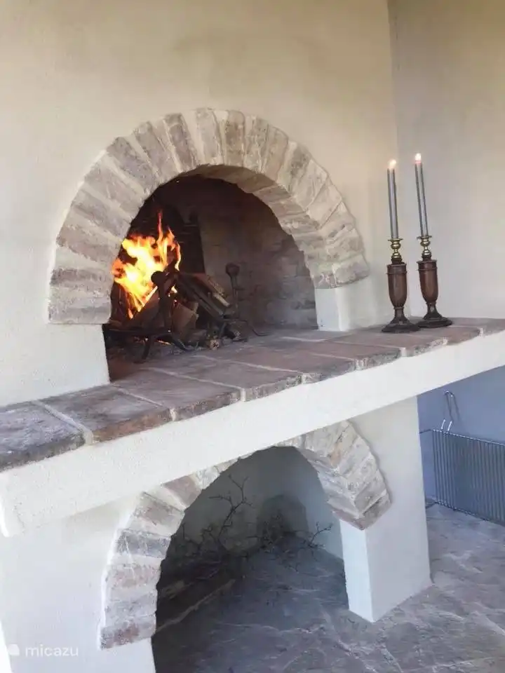 Une belle cheminée, qui peut aussi servir de BBQ, à côté de la cuisine avec une belle longue table