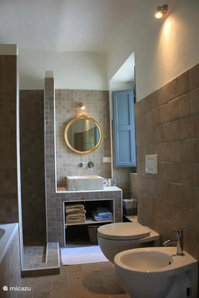 La salle de bain est en bas, avec baignoire, douche et WC