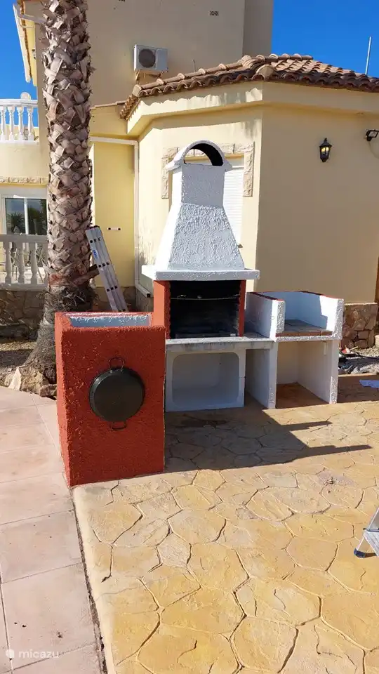 Una hermosa barbacoa grande junto a la piscina junto a la terraza y las tumbonas donde podrá disfrutar de una deliciosa comida.