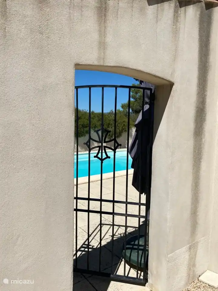 Vista desde la terraza delantera a la piscina, puerta con llave.