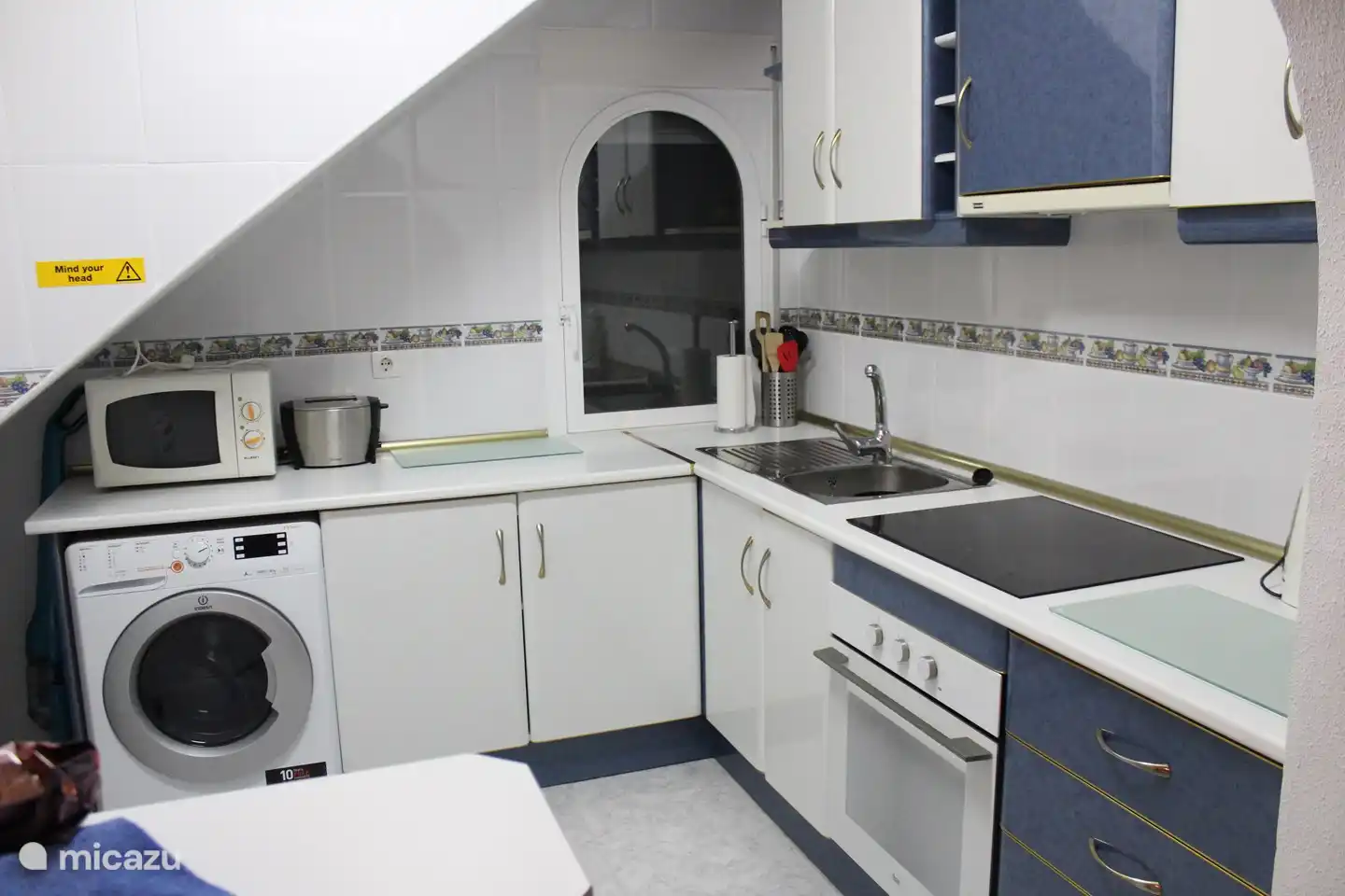 Cocina con combinación de lavadora / secadora. También hay una cafetera. 