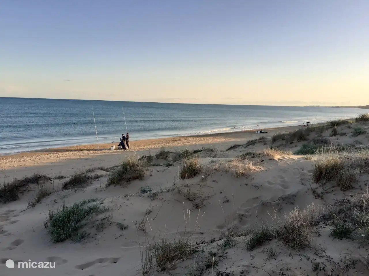 Una bella escena invernal: pescadores a lo largo de la costa.