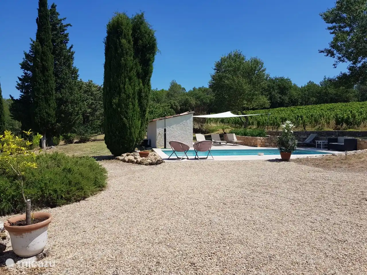 Zicht vanaf de voorzijde van Le Poulailler op het zwembad en terras