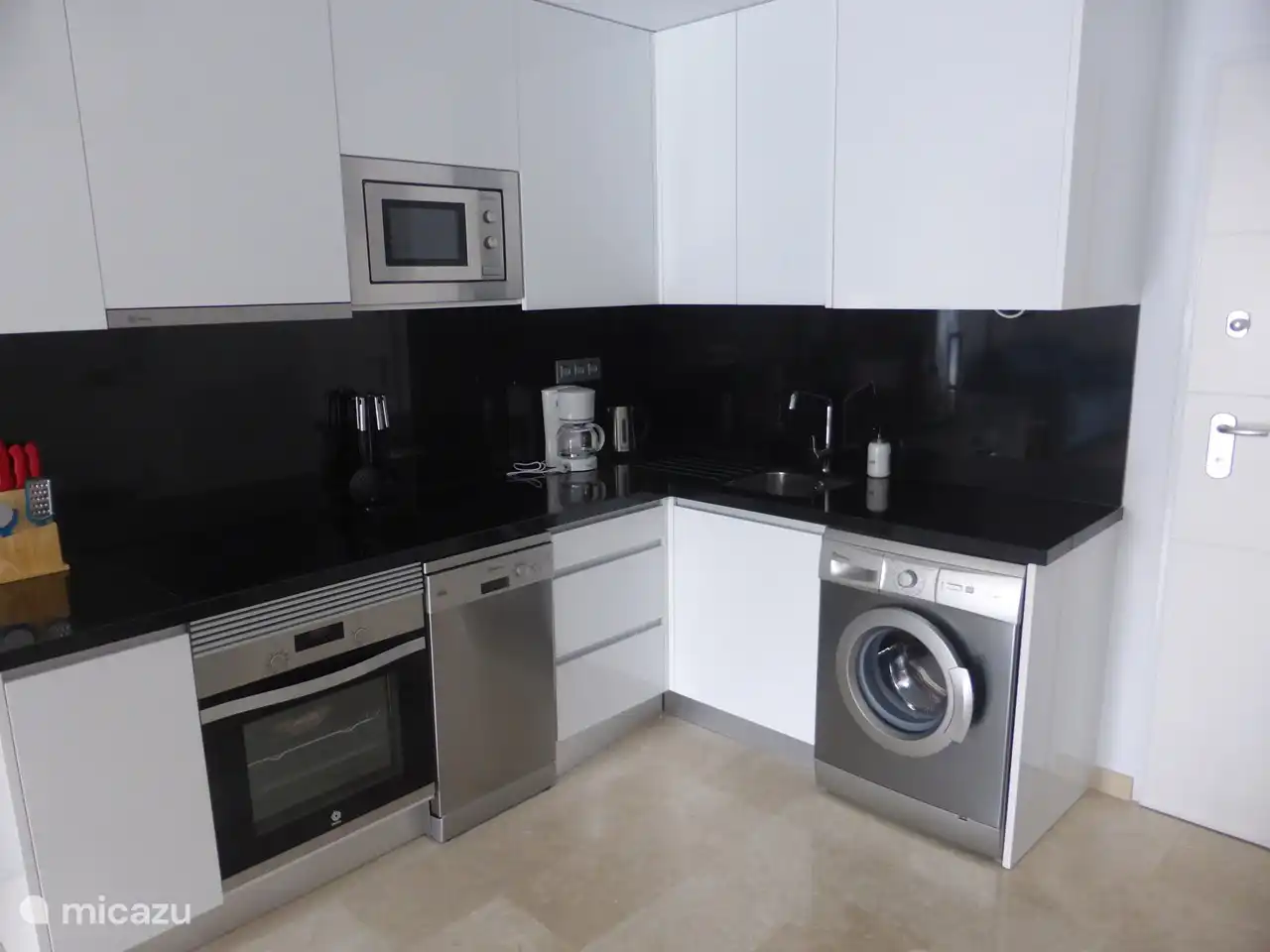 Bloc cuisine avec micro-ondes, four, lave-vaisselle et lave-linge.