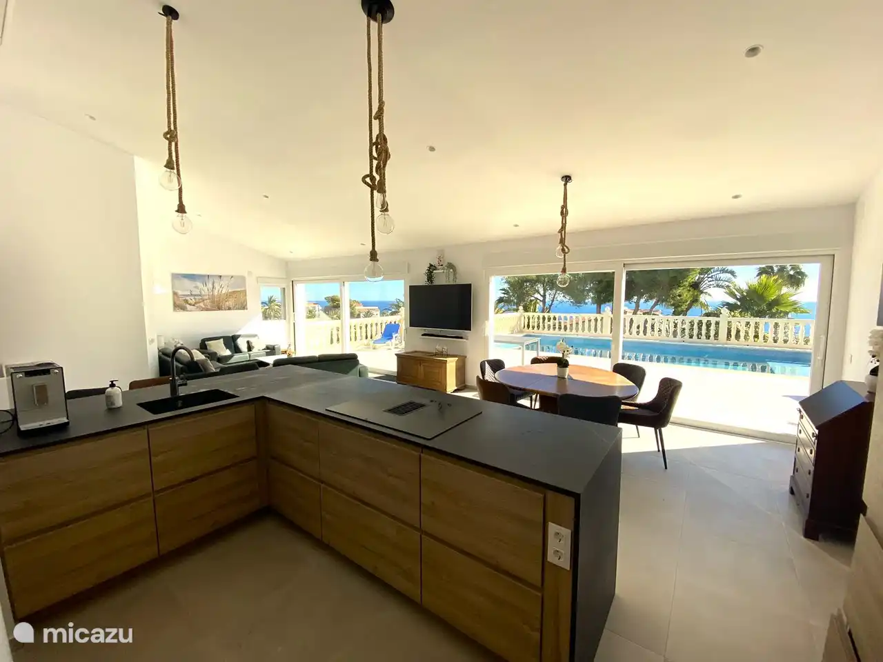 Sehr geräumige offene Küche mit Bar und Blick auf den Sitz- und Essbereich mit 2 großen Schiebetüren. Auf diese Weise haben Sie einen direkten Blick auf die Terrasse und den Pool und können Ihre Kinder genau im Auge behalten. 