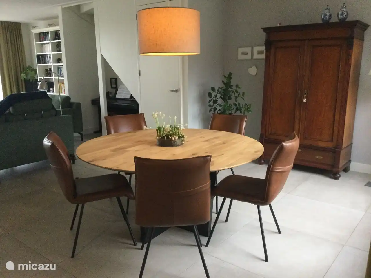 Ein gemütlicher runder Esstisch grenzt an die offene Küche mit Blick auf den Wald.