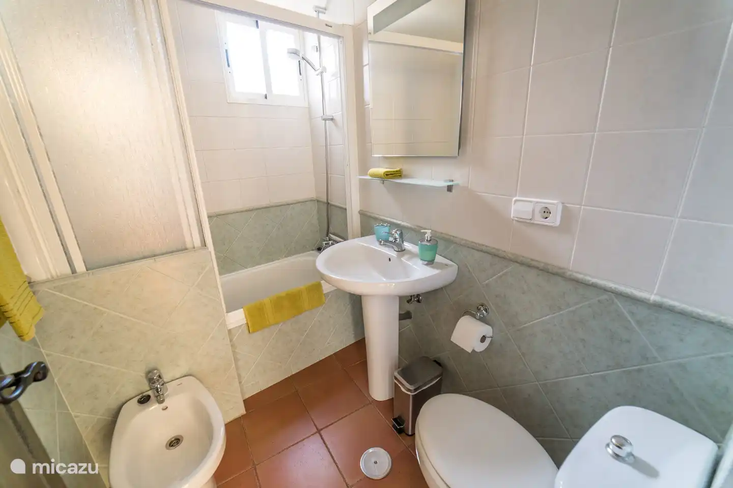 praktisches Badezimmer mit Badewanne / Dusche, Waschbecken, Toilette und Bidet. Handtücher, Toilettenpapier und Handseife sind vorhanden. auch ein Fön.