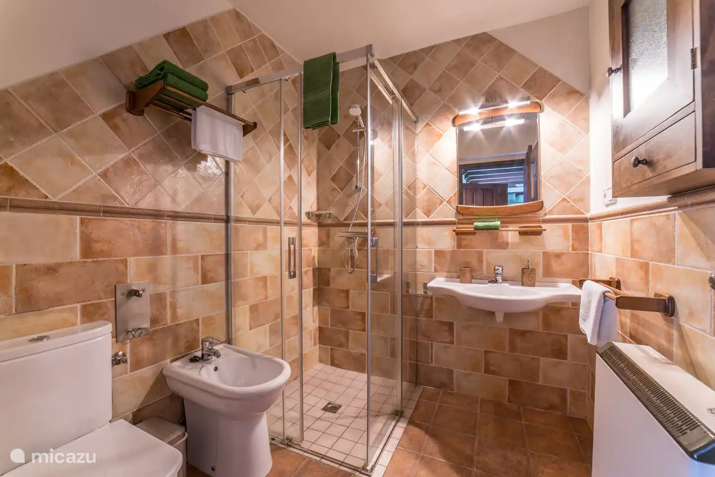 komplettes Badezimmer mit Dusche, Waschbecken, Toilette und Bidet. Handtücher, Toilettenpapier und Handseife, Handseife und Haartrockner sind ebenfalls vorhanden.