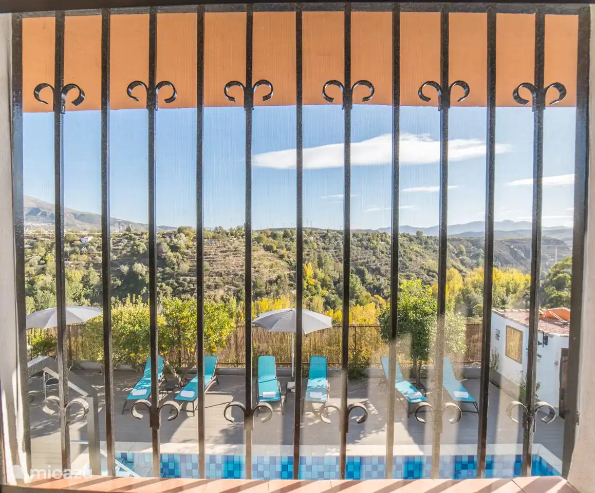blick auf das schwimmbad und die berge dahinter.