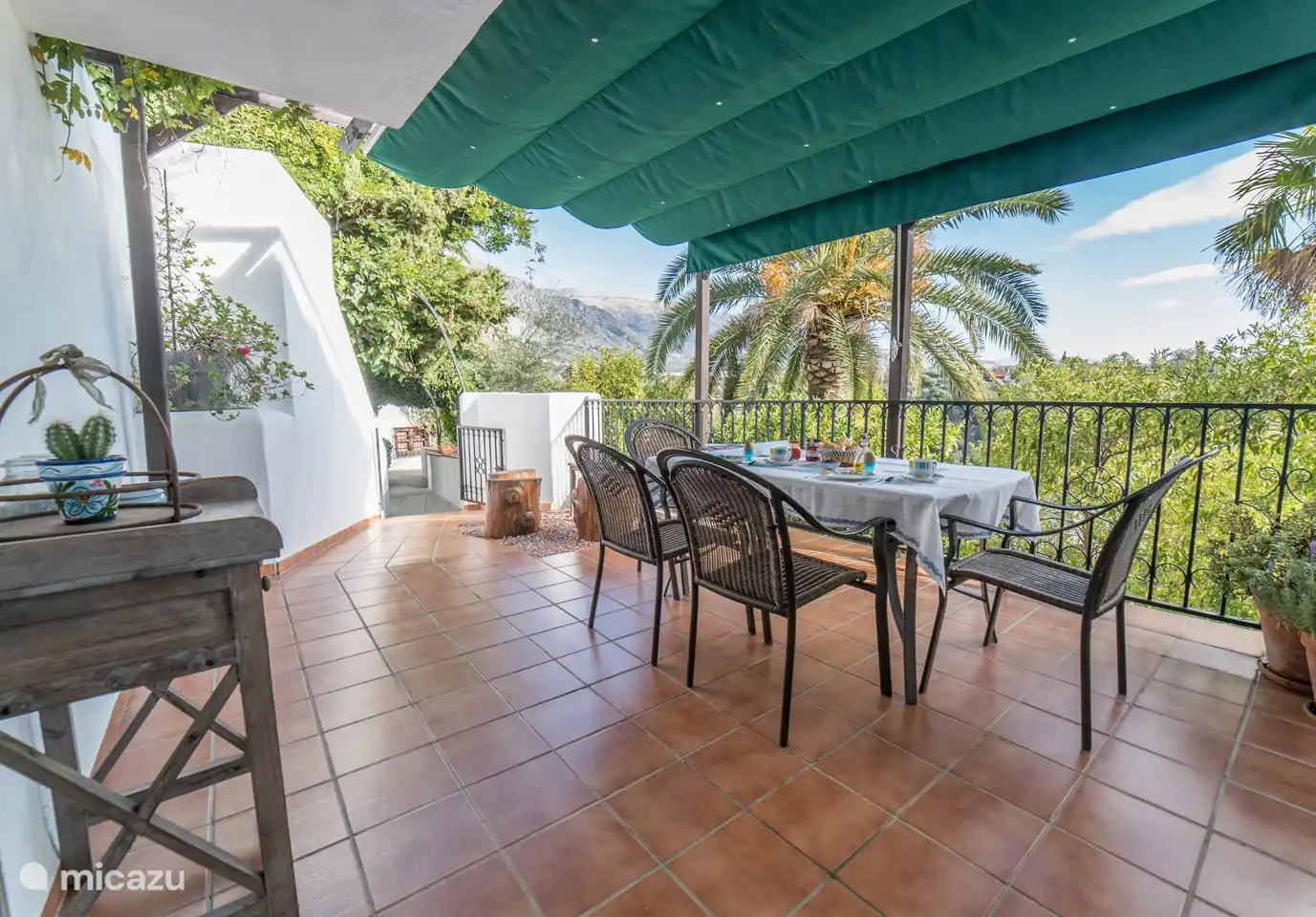 Die Außenterrasse mit Tisch, 4 Stühlen, separatem Sitz und Wäscheständer.