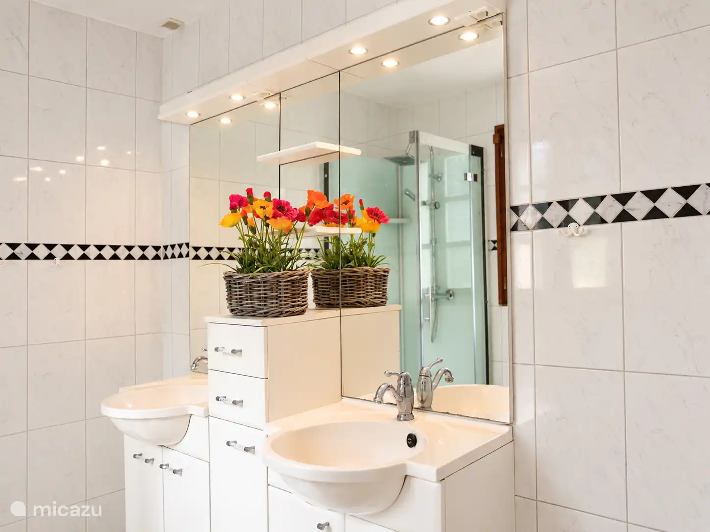Ein weiterer Blick auf das Badezimmer mit Waschbecken und großem Spiegel.