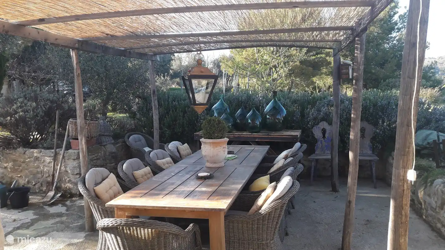 Tisch + Stühle im Schatten der Pergola 