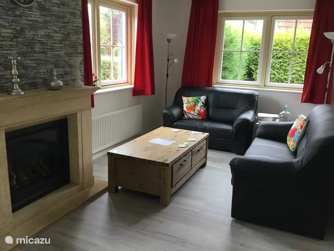 Foto des Wohnzimmers mit zwei großen Fenstern. Das Wohnzimmer hat insgesamt 4 große Fenster, die viel Licht in den Raum bringen.