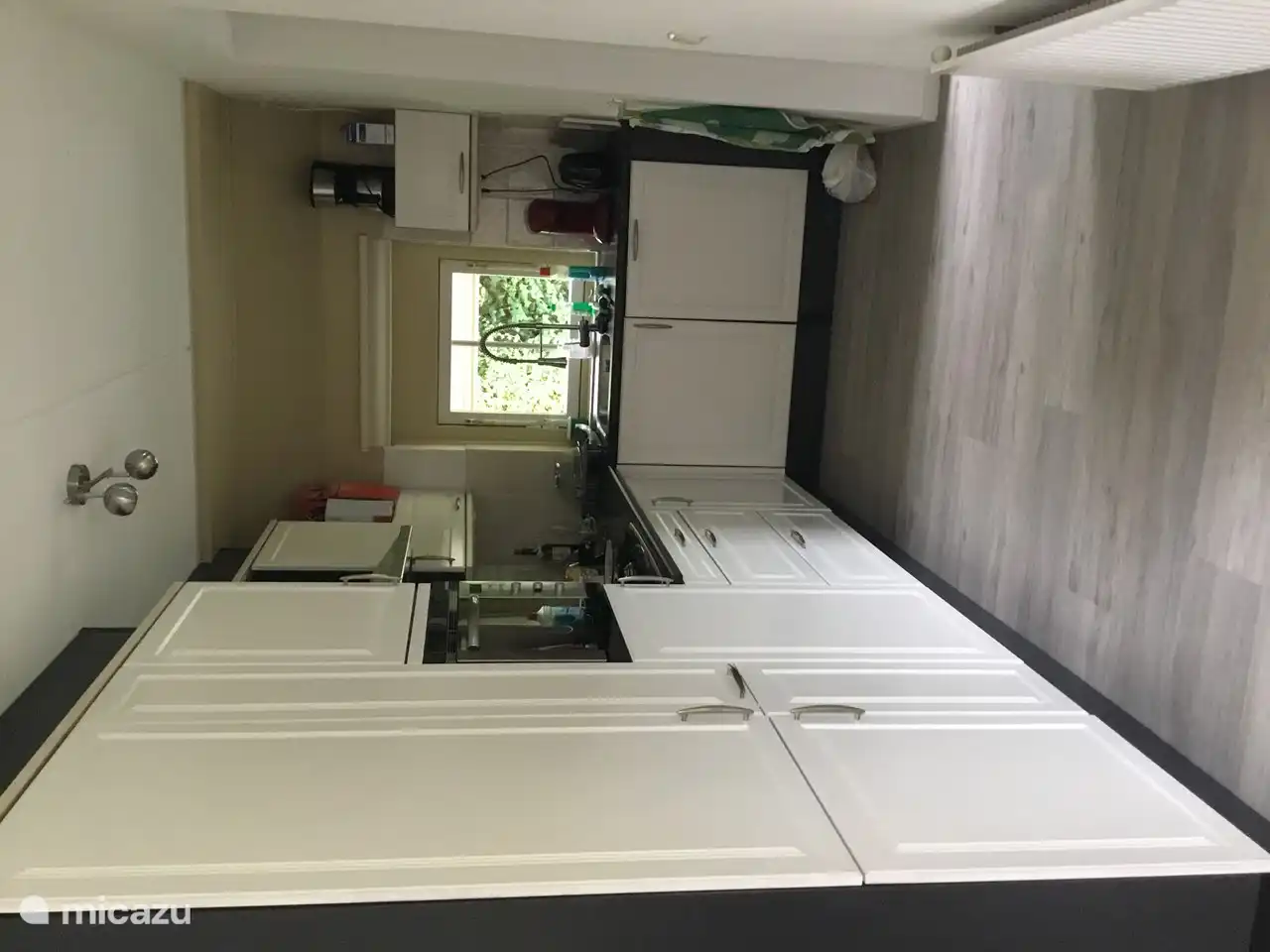 Die Küche befindet sich links vor der Gartentür. Moderne Farbe. Sehr komplett mit einer Kühl- / Gefrierkombination, einer Kombimikrowelle und einem Geschirrspüler.