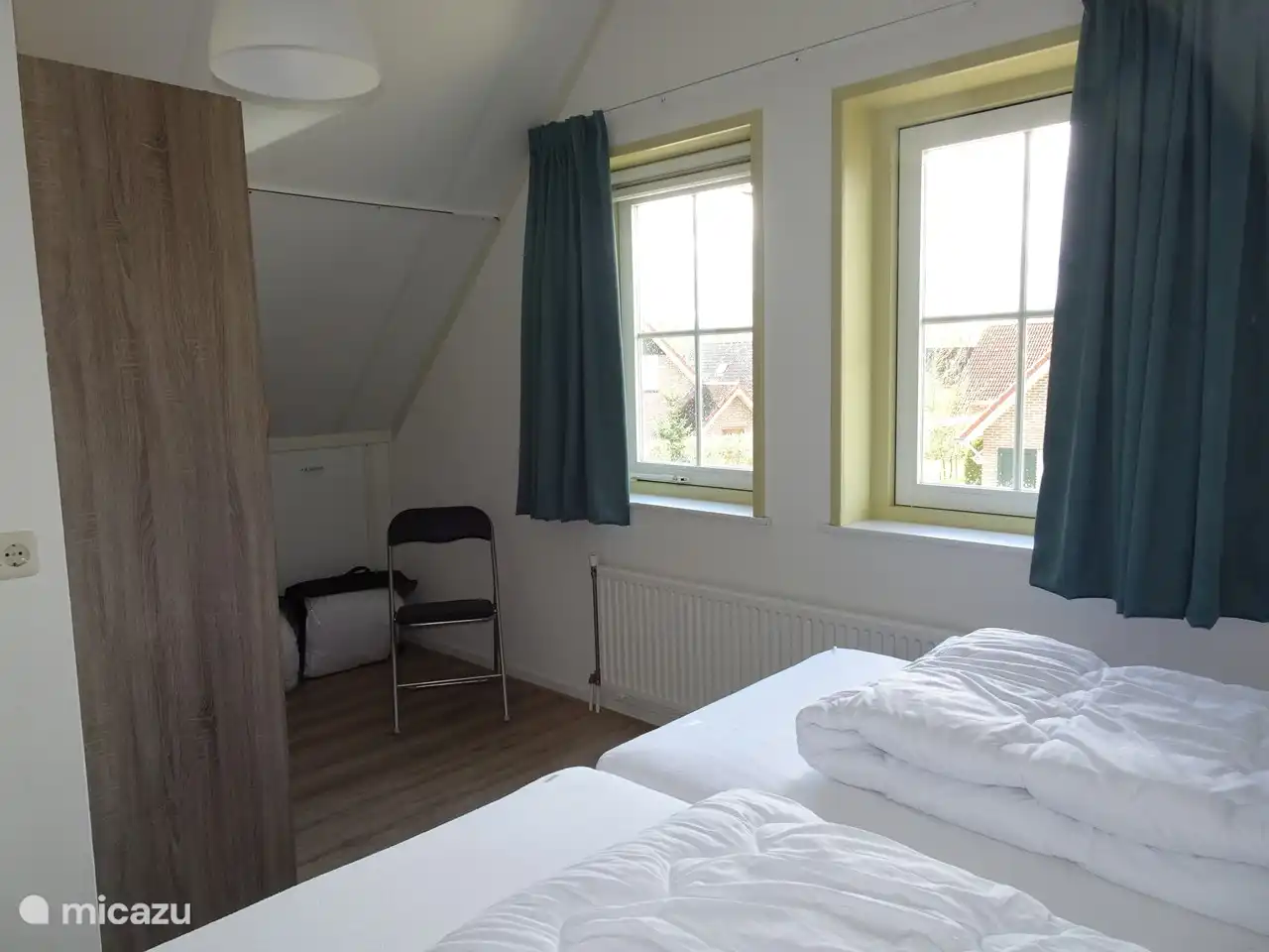 Im kleinsten vorderen Schlafzimmer befindet sich unter anderem ein Schrank mit Platz zum Aufhängen, Stauraum und drei Schubladen sowie ein Stuhl.