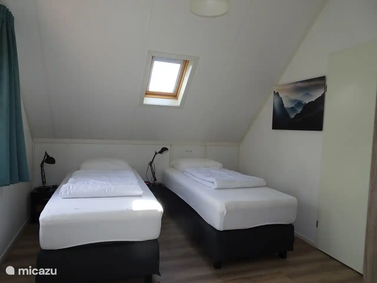 Im hinteren Schlafzimmer (dem größten) befinden sich zwei Boxspringbetten, zwei Nachttische mit Leselampen und ein Radiowecker.