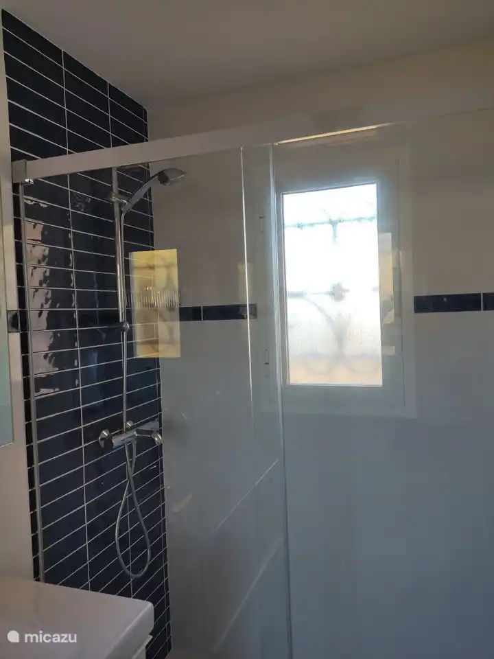 Brand new bathroom with spacious walk-in shower, washbasin, towel radiator and hanging toilet