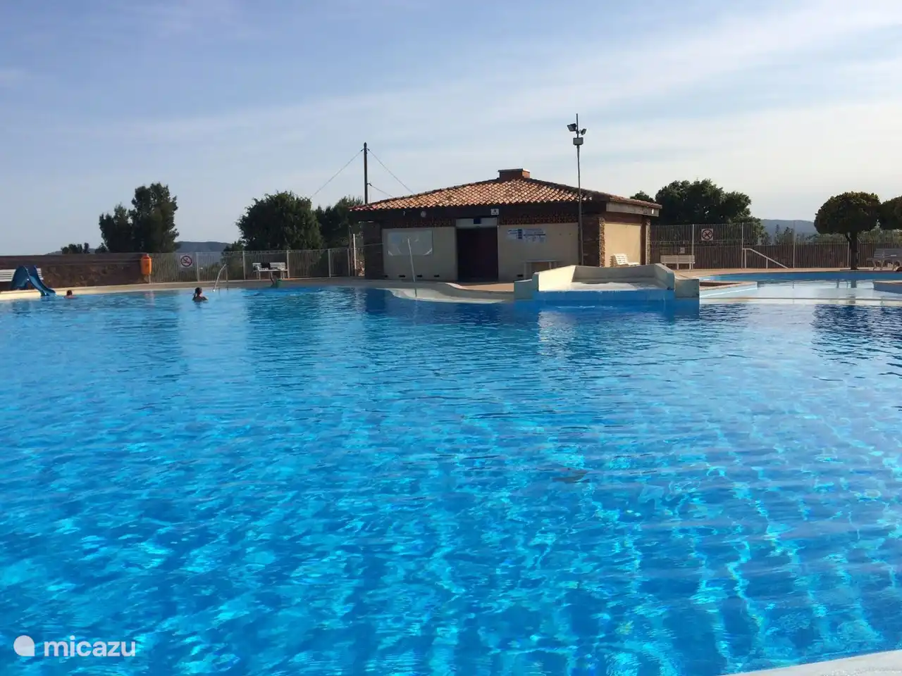 Schwimmbad mit Sanitäranlagen und Rettungsschwimmerstation.