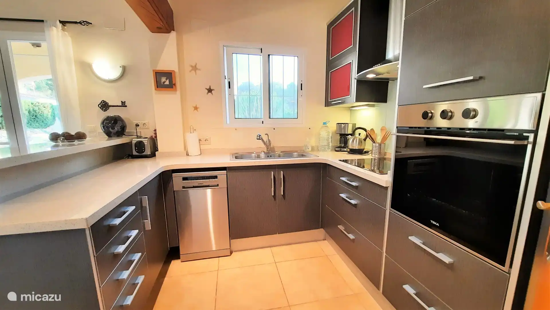 La cuisine ouverte avec four, micro-ondes, lave-vaisselle, etc.