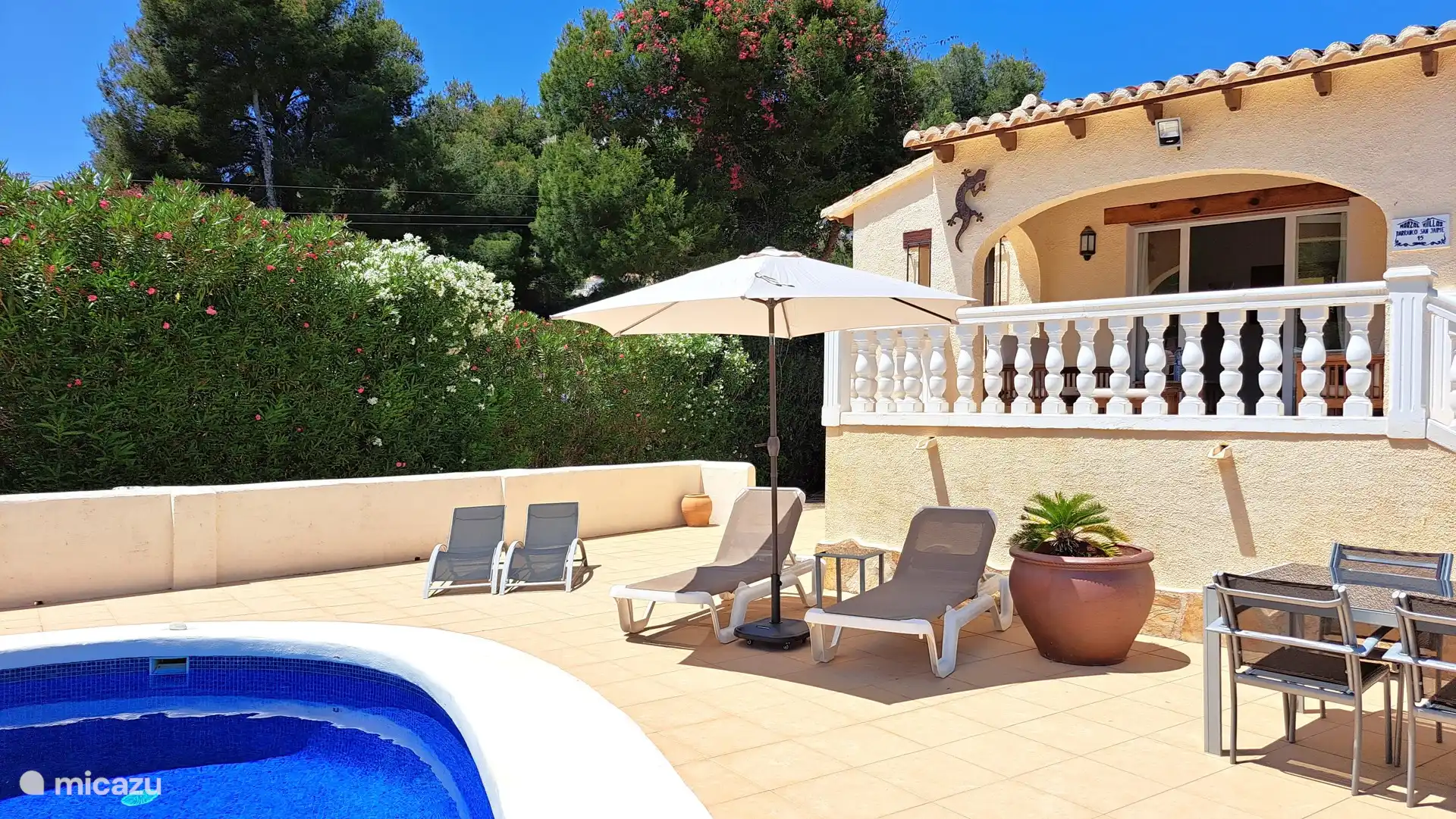 Chaises longues confortables avec parasol au bord de la piscine