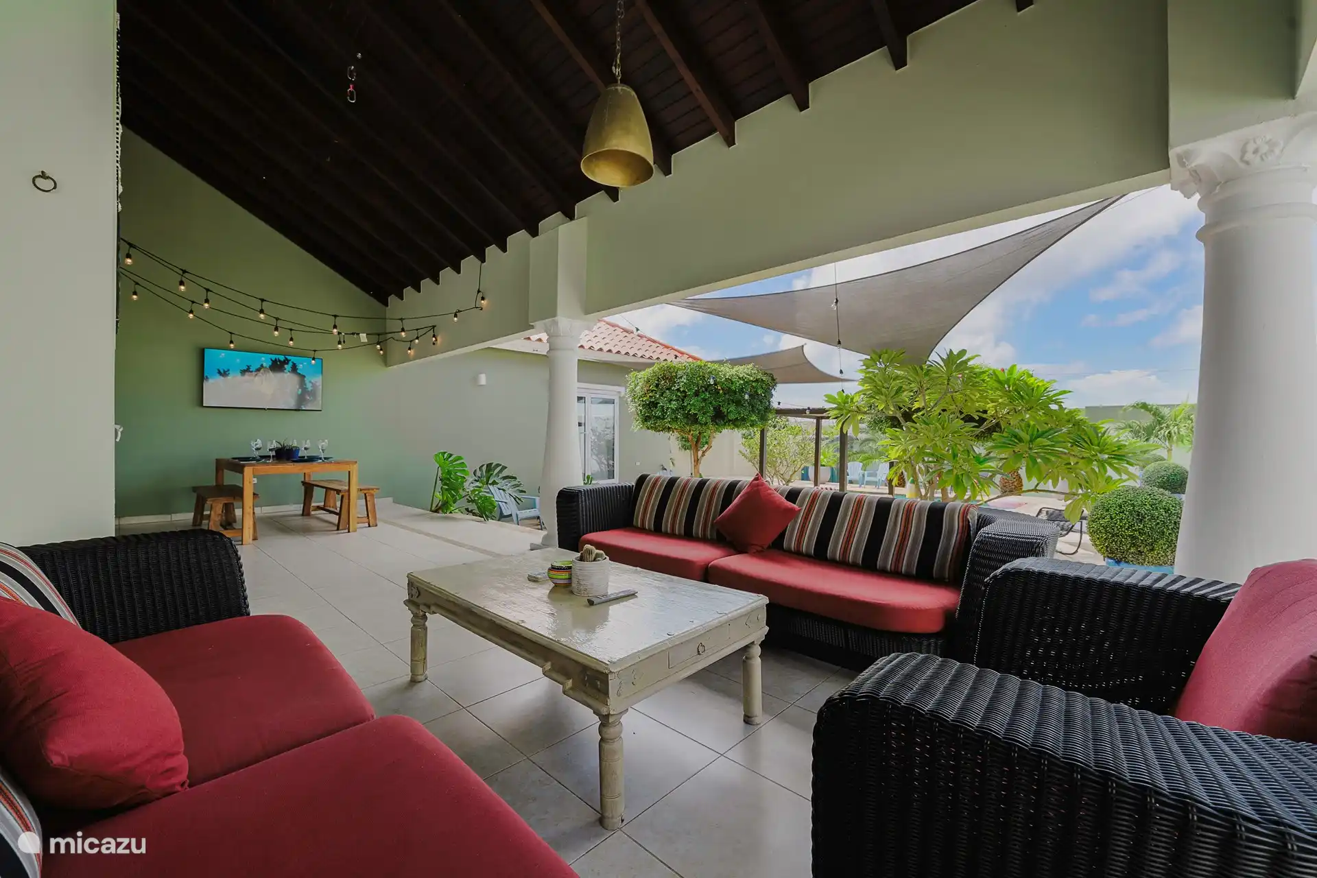 amplio patio con una gran mesa de comedor, sofás y un televisor inteligente 