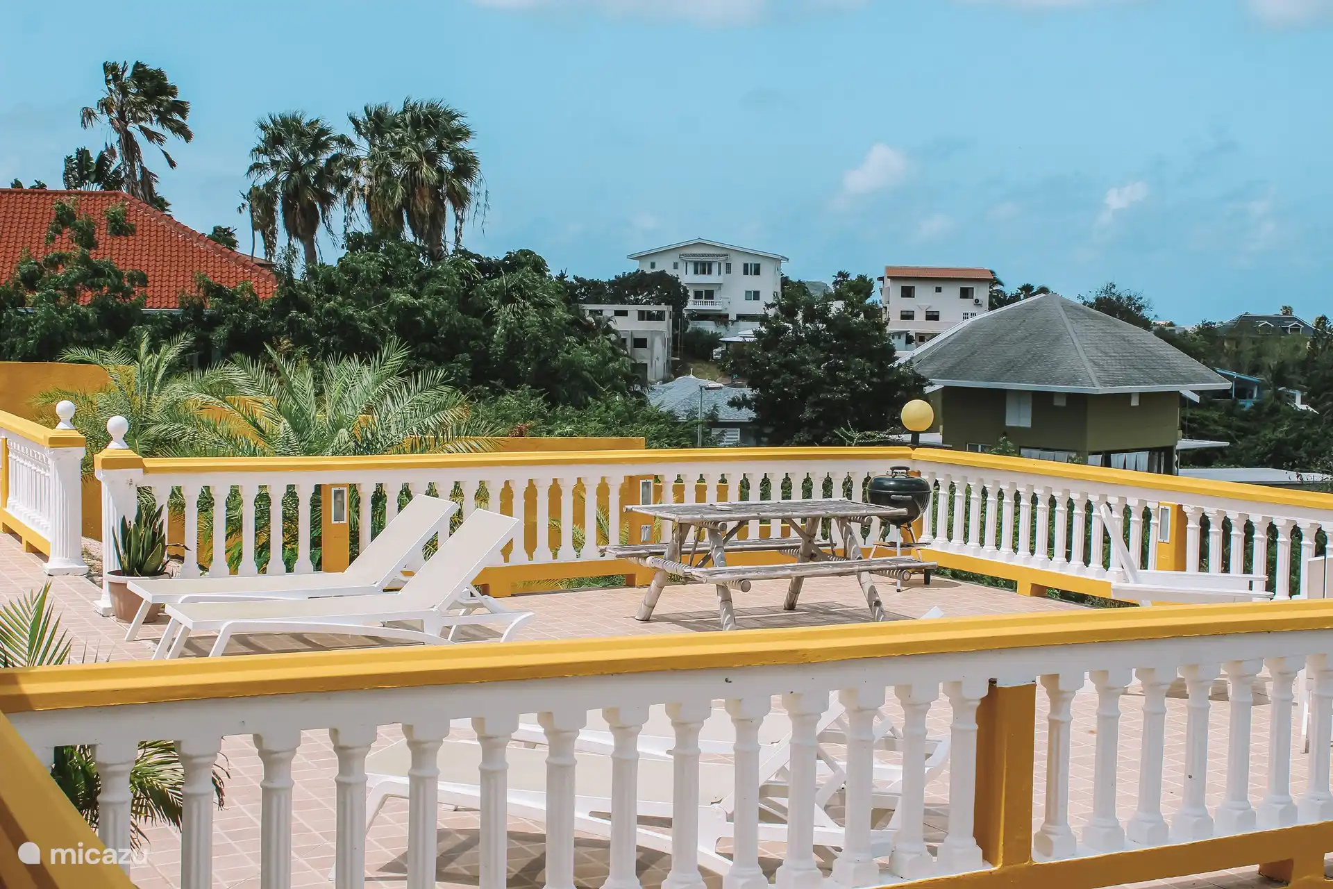 La terrasse commune avec BBQ et divers salons/coins salons.