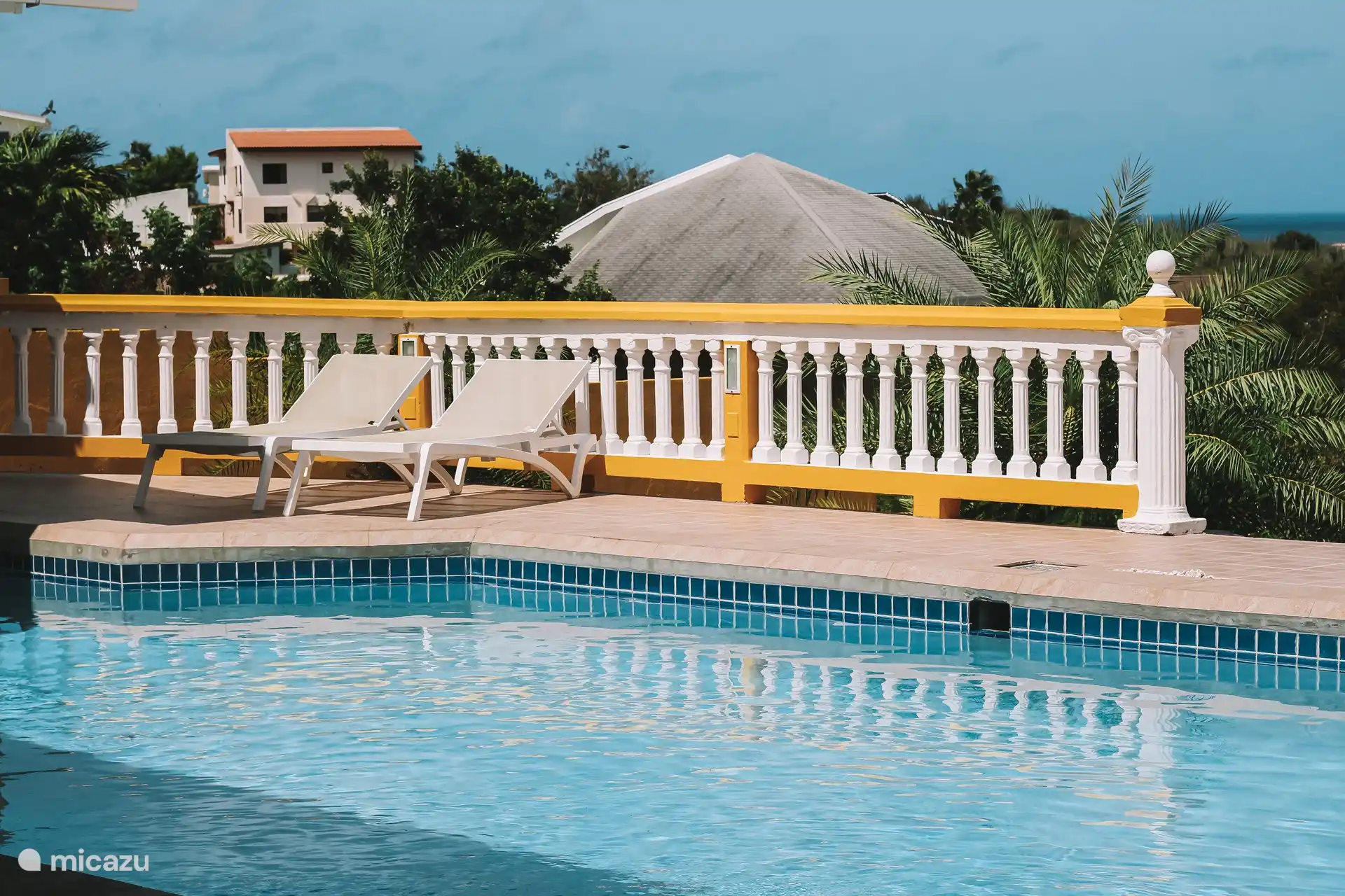 La piscine avec divers transats.