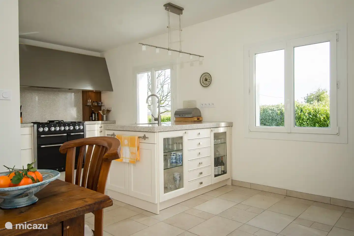 Küche mit Spuleninsel und dahinter Blick auf den Backofen/Herd mit Dunstabzugshaube