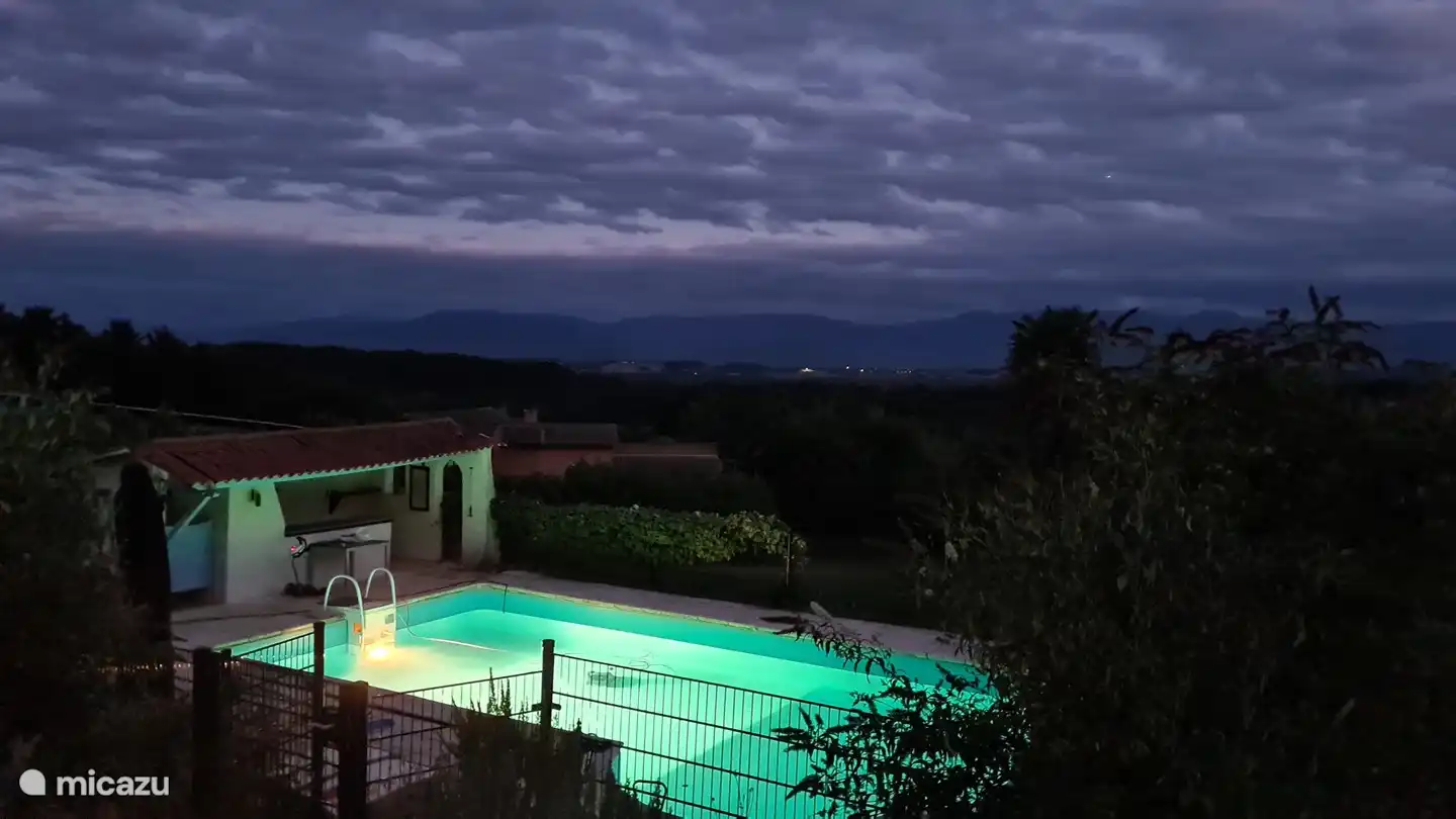 Aussicht kurz nach Einbruch der Dunkelheit, bei eingeschaltetem Licht im Pool