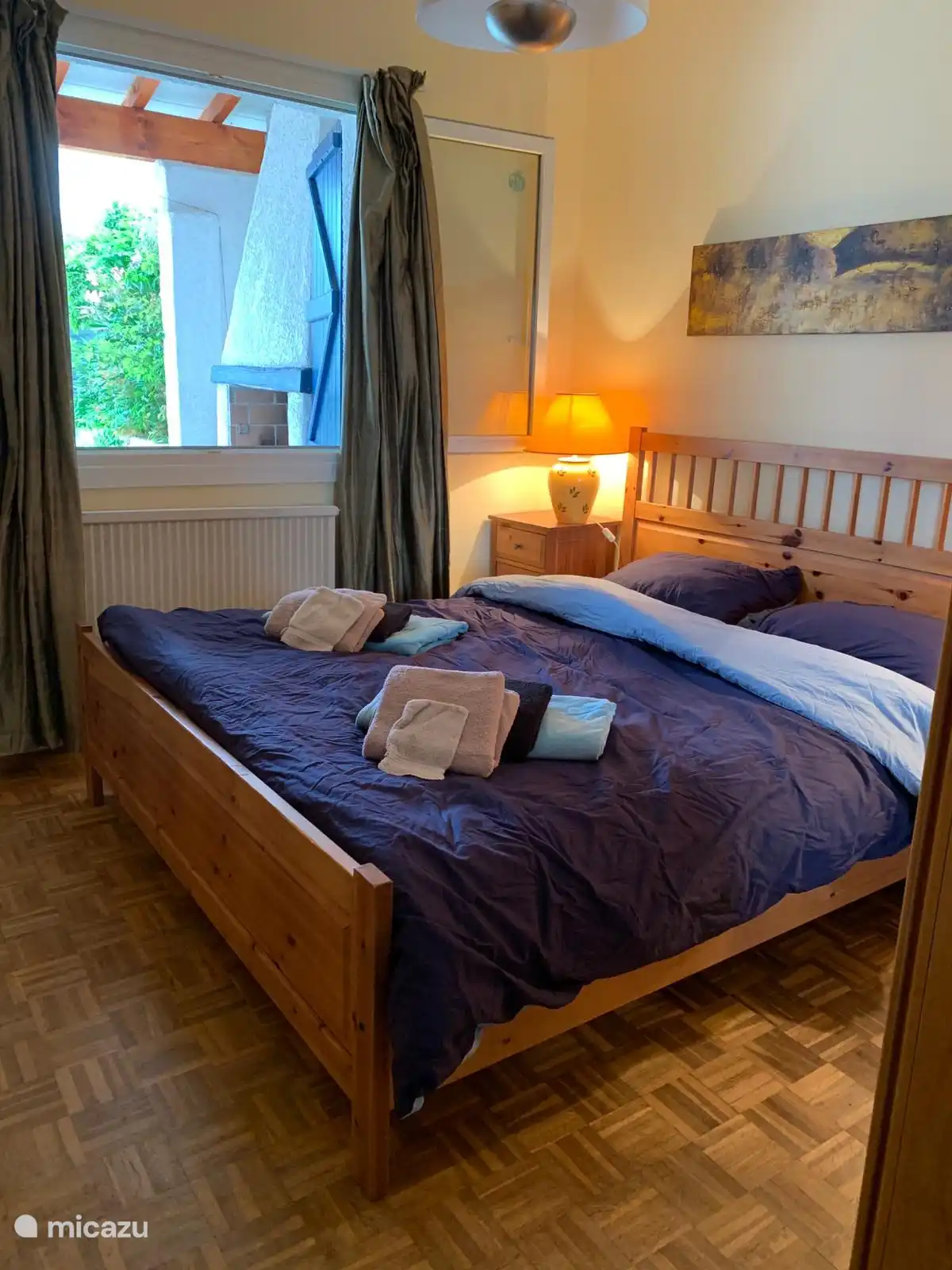 Schlafzimmer 2, angrenzend an die Terrasse, der Außenkamin ist im Hintergrund des Fotos sichtbar