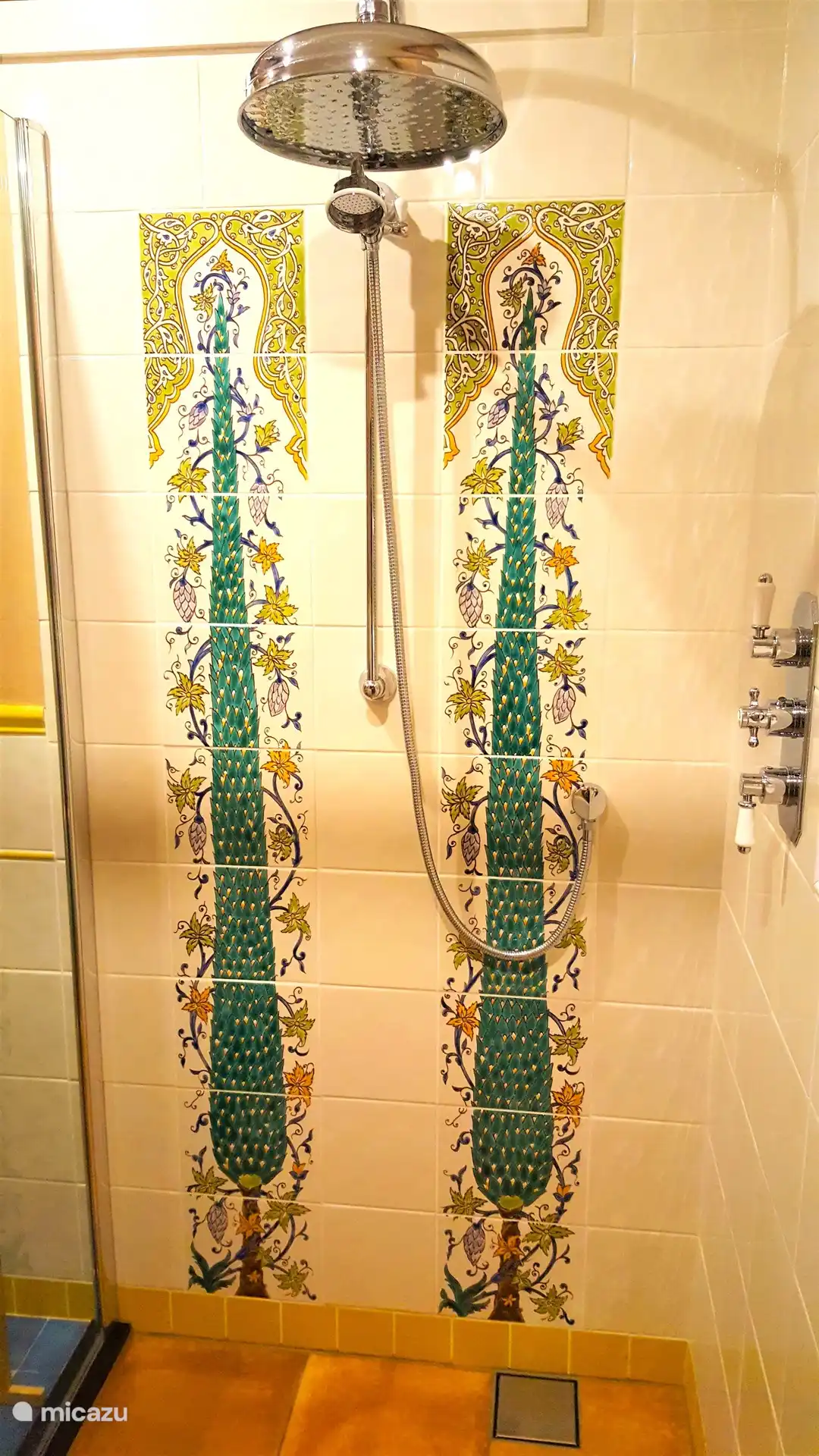 eine Rückwand aus von Hand bemalten italienischen Zypressen. Die Duscharmaturen kommen wieder aus England. Ein schönes Ganzes.