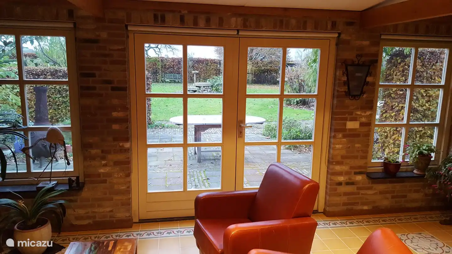 Im Wohnzimmer befinden sich 2 bequeme Sessel. Dreh dich um und du schaust direkt in den Garten.