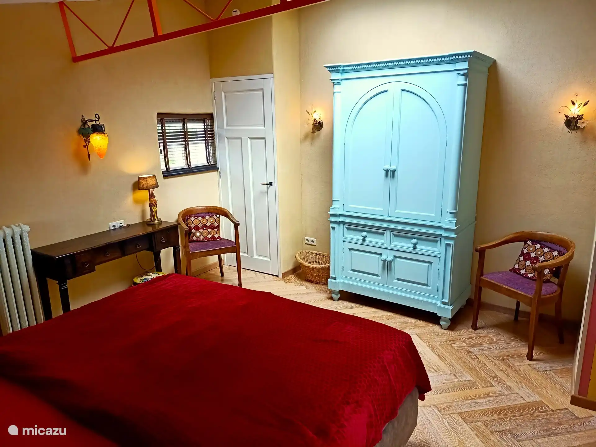 Das Schlafzimmer war ursprünglich ein Stall. Darin der authentische Balken, den wir in auffälligem Orange gestrichen haben.