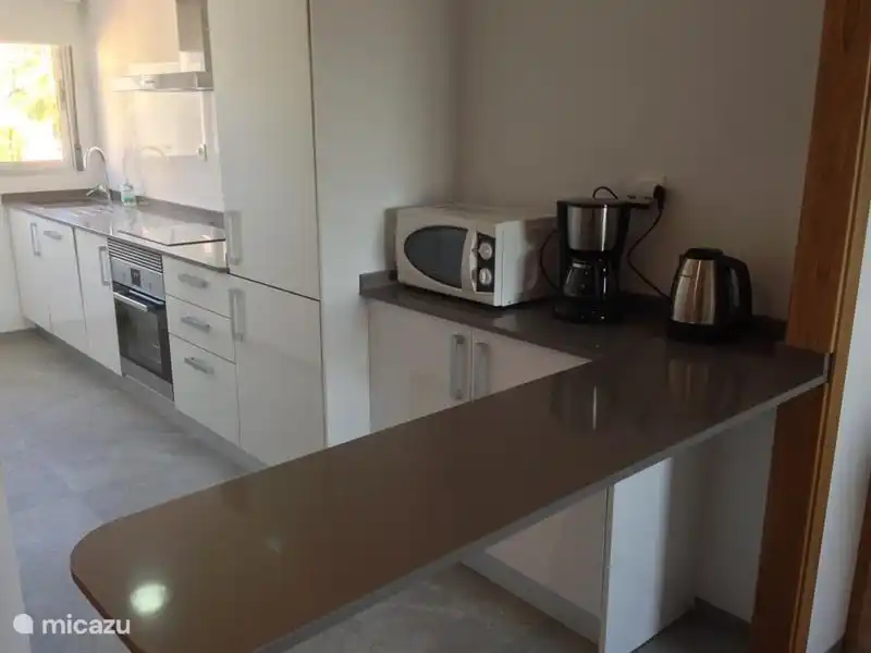 Cocina con microondas y barra.