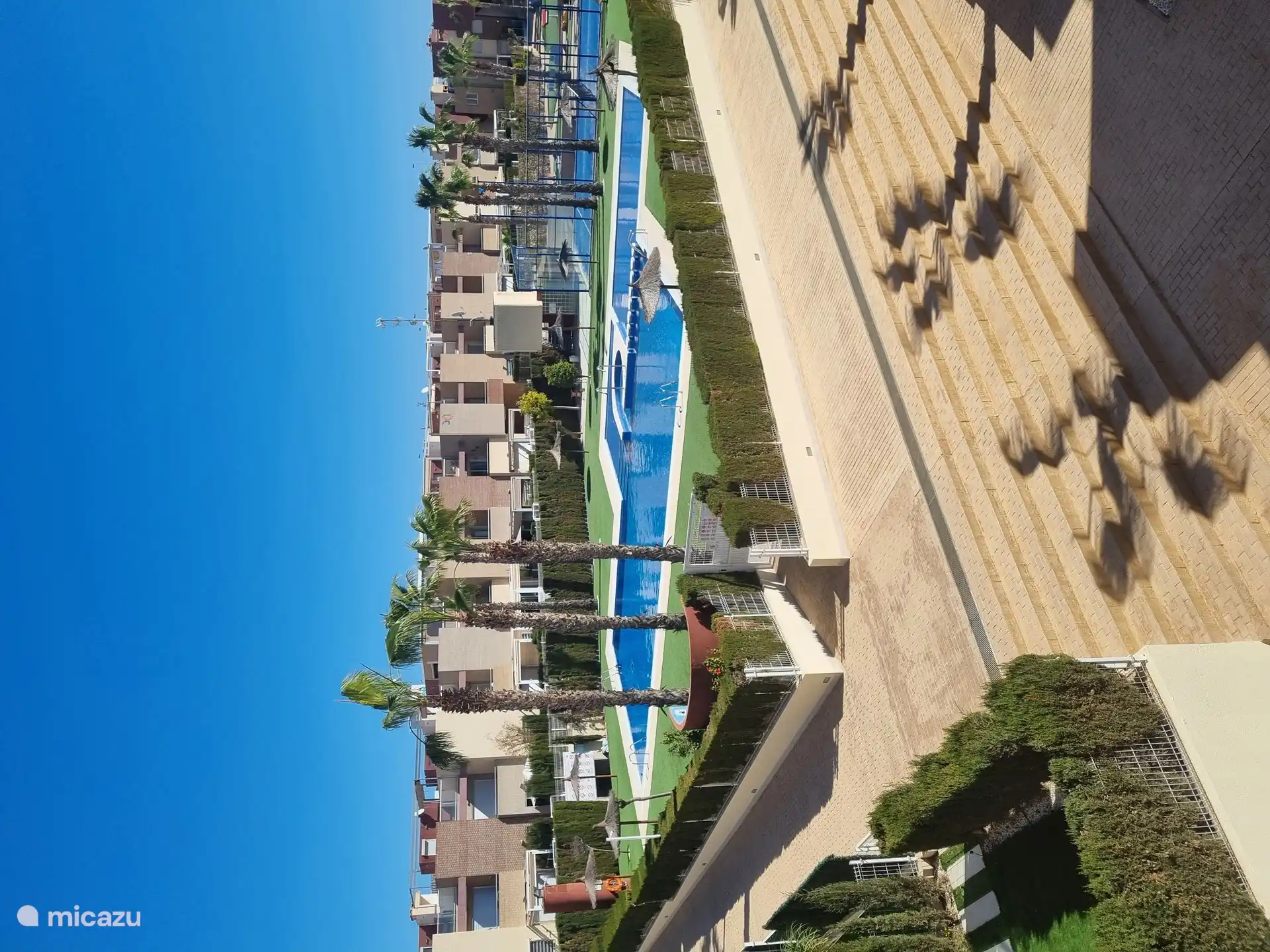 Vista sobre la piscina y la pista de pádel.