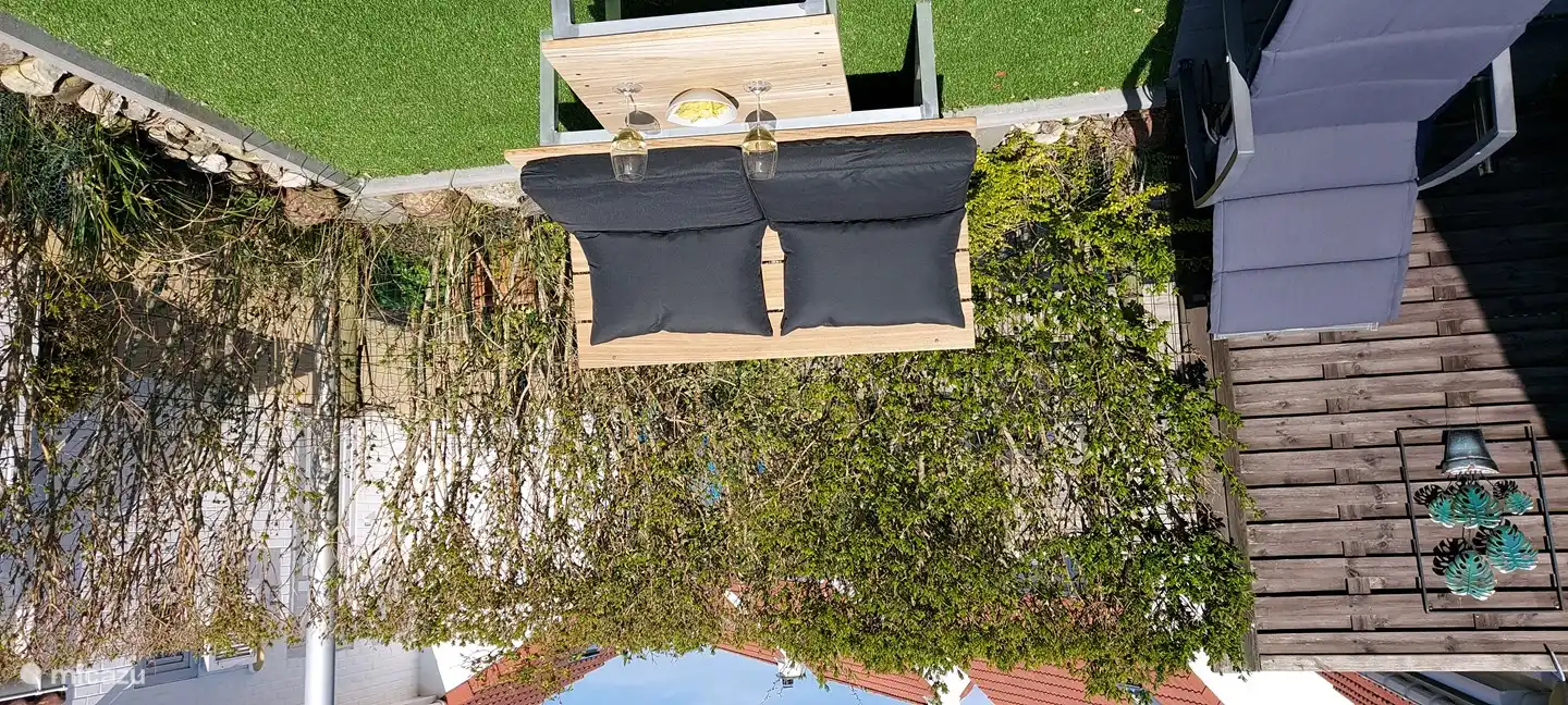 zuidgerichte tuin met 2 ligbedden, loungebank en eettafel