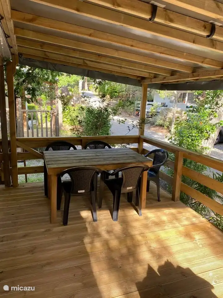 Jolie véranda couverte avec table à manger et salon