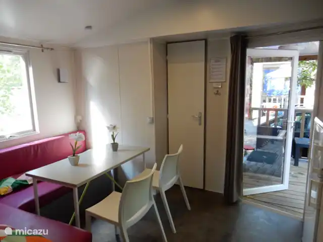 stacaravan huren in Frankrijk, Côte d´Azur, Roquebrune-sur-Argens – Stacaravan bij zee Zuid-Frankrijk Eettafel met bank en aparte stoelen. Openslaande deuren naar het terras.