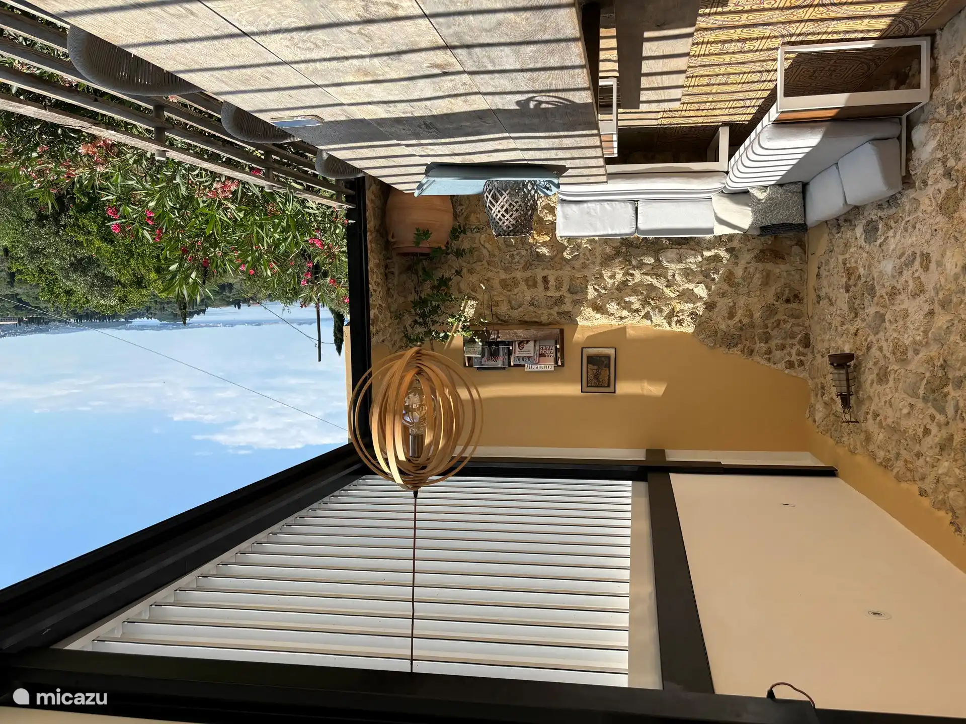 Terrasse mit Lounge-Sofa unter Lamellendach