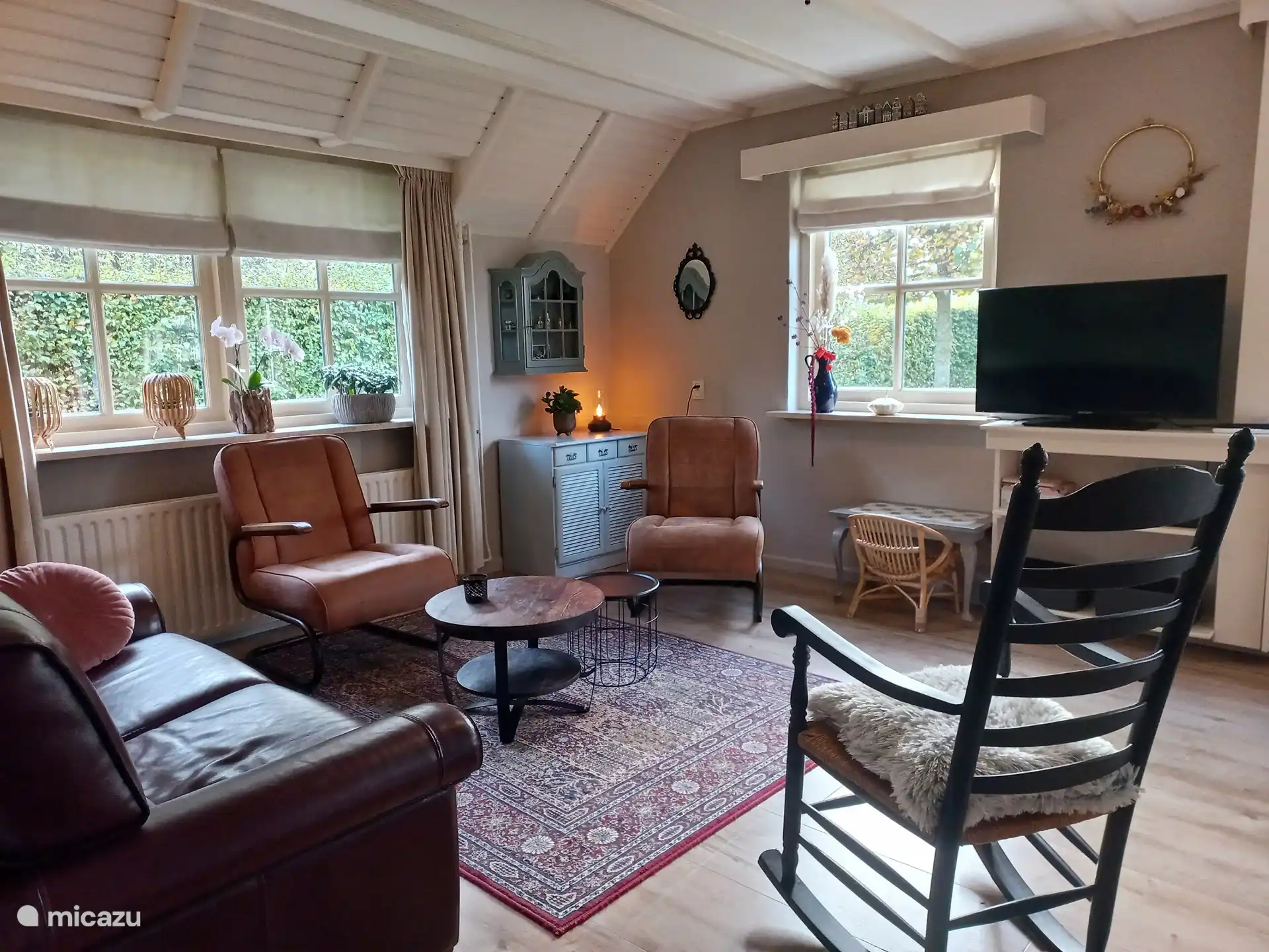 Woonkamer comfortabele stoelen en bank.
Smart TV. Spelletjeskast.