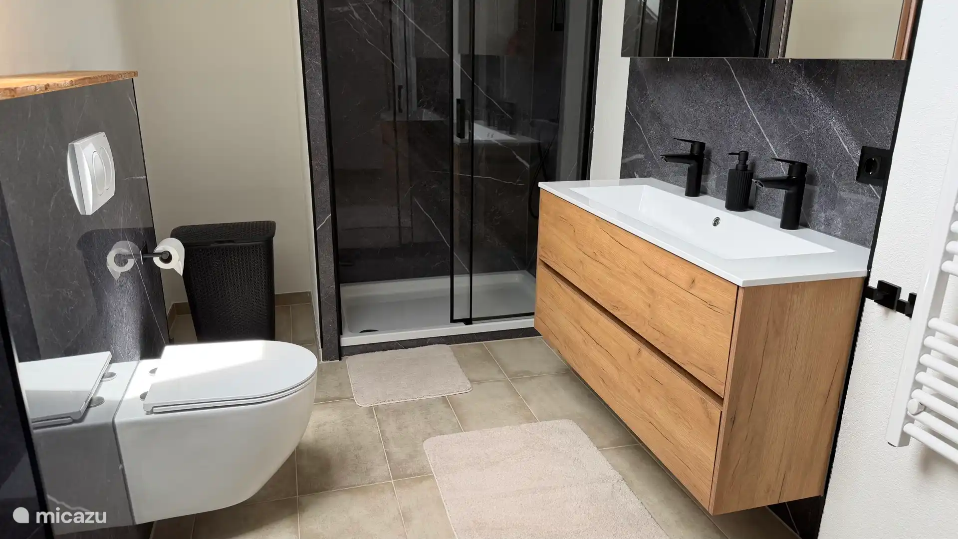 De nieuwe badkamer met ligbad, toilet, ruime doucheruimte, dubbele wastafel, vloerverwarming, nieuw ruimer Velux dakraam