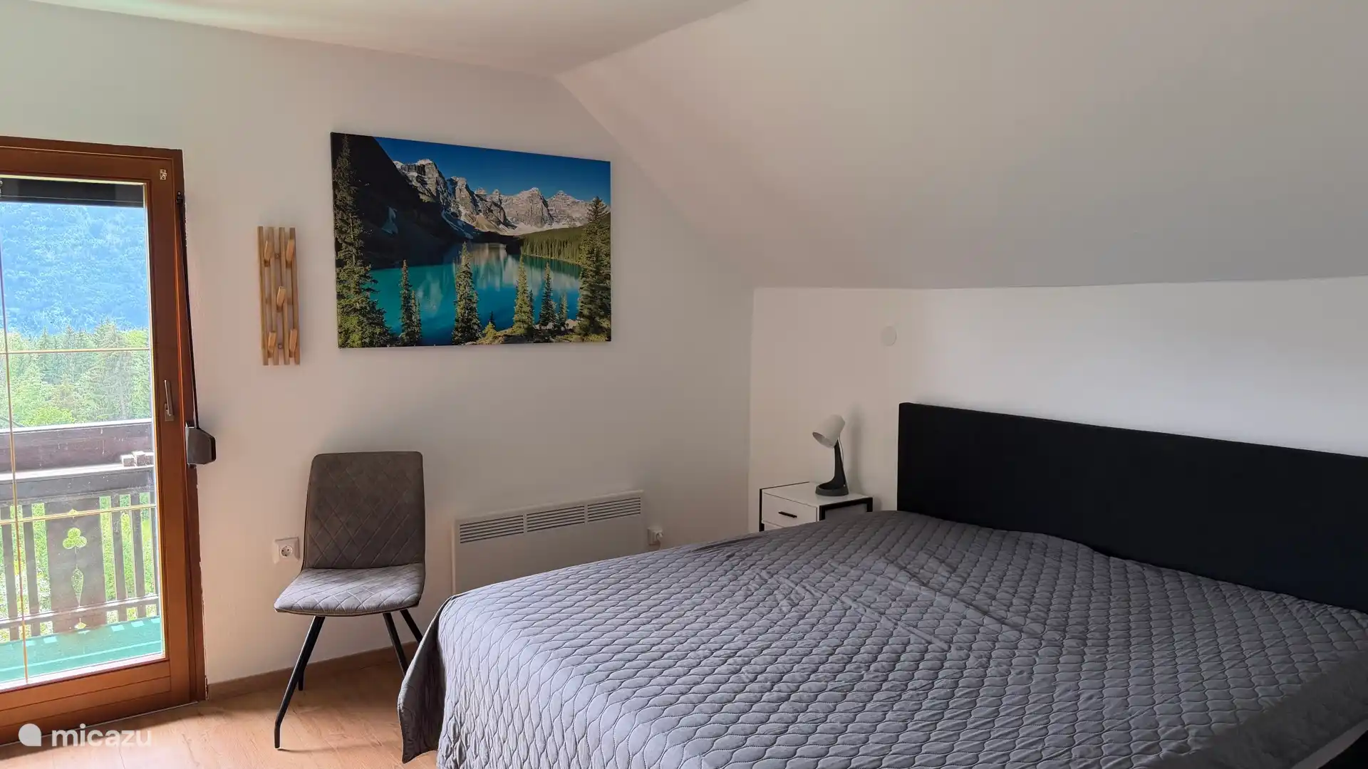 Ruime slaapkamer met boxspring 180 x 200 
Grote ruime schuifdeuren kledingkast met balkon met zicht op de tuin, de Oostenrijkse, Italiaanse en Sloveense bergen 
